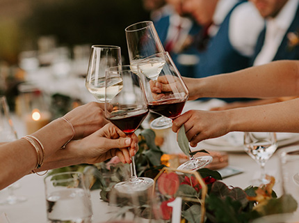 Four people toasting with glasses of wine at a dinner table